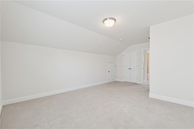 bonus room featuring light carpet, lofted ceiling, and baseboards