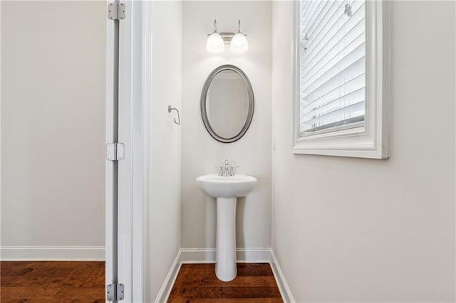 bathroom with wood finished floors, baseboards, and a sink