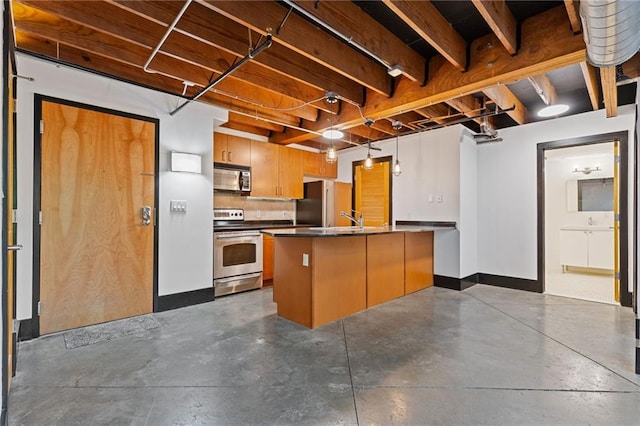 kitchen featuring backsplash, a center island with sink, sink, and appliances with stainless steel finishes