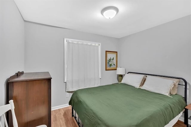 bedroom with wood finished floors and baseboards