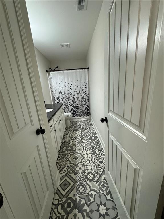 bathroom with vanity, a shower with shower curtain, and toilet