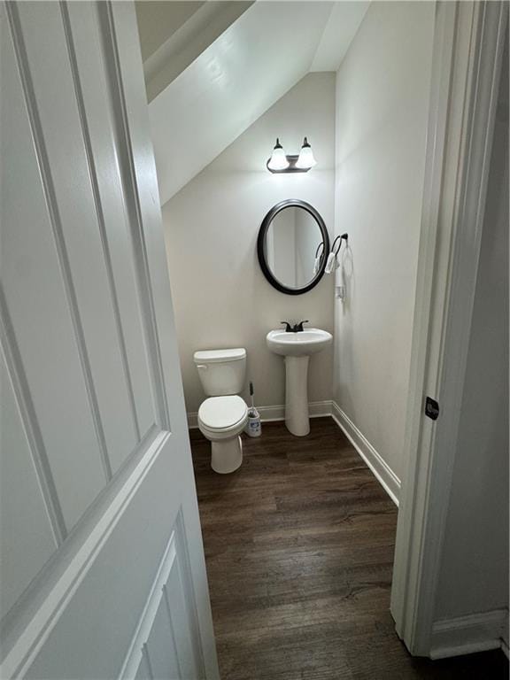 bathroom featuring lofted ceiling, hardwood / wood-style floors, sink, and toilet