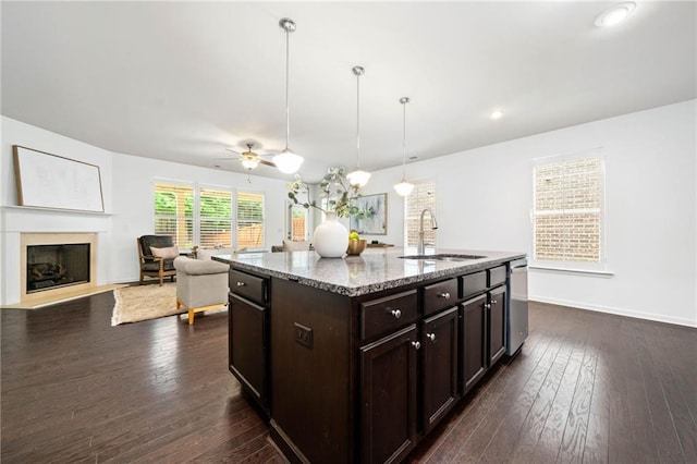 123 Meridian Dr, Woodstock, GA 30188 - kitchen with a sink, light stone countertops, dark brown cabinetry, dark wood-style floors, and open floor plan