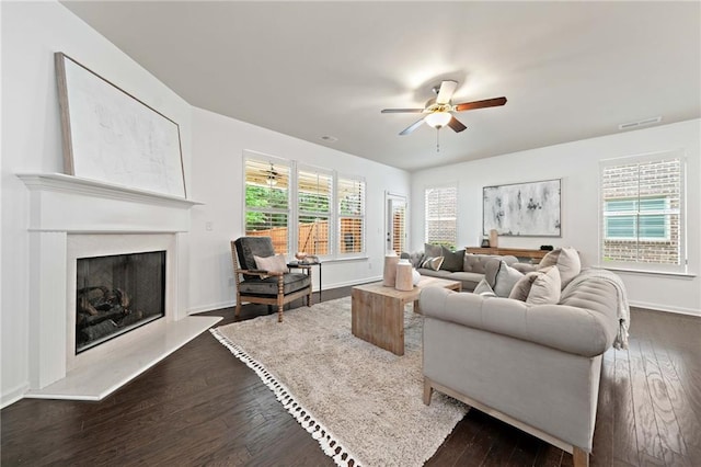 123 Meridian Dr, Woodstock, GA 30188 - living area featuring a ceiling fan, dark wood-style floors, a fireplace with raised hearth, and baseboards