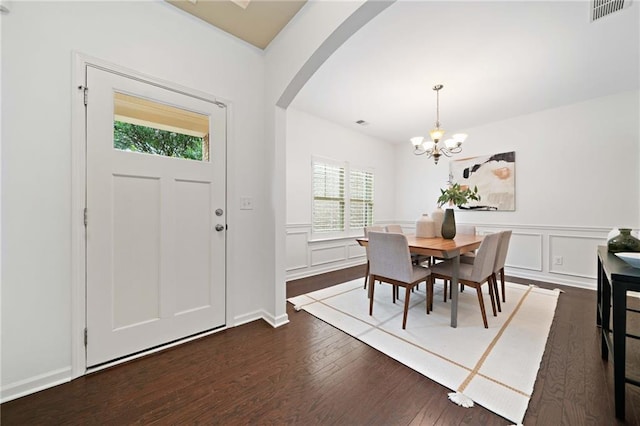 123 Meridian Dr, Woodstock, GA 30188 - dining room featuring arched walkways, plenty of natural light, a chandelier, dark wood finished floors, and wainscoting