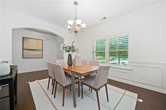 123 Meridian Dr, Woodstock, GA 30188 - dining room with a chandelier, arched walkways, dark wood-style floors, and a wainscoted wall