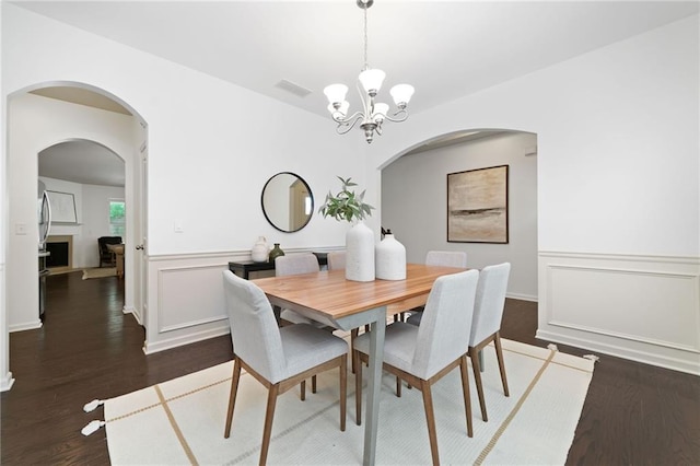 123 Meridian Dr, Woodstock, GA 30188 - dining room with arched walkways, dark wood-style flooring, and a chandelier