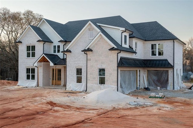 view of front facade featuring a standing seam roof, stone siding, and metal roof