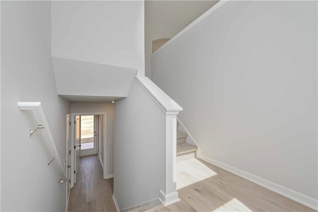 staircase featuring baseboards and wood finished floors