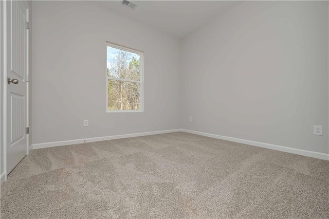 carpeted spare room featuring visible vents and baseboards