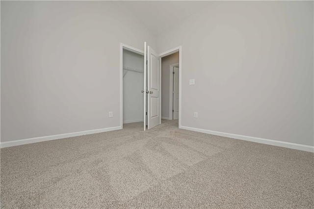 spare room featuring baseboards and light carpet