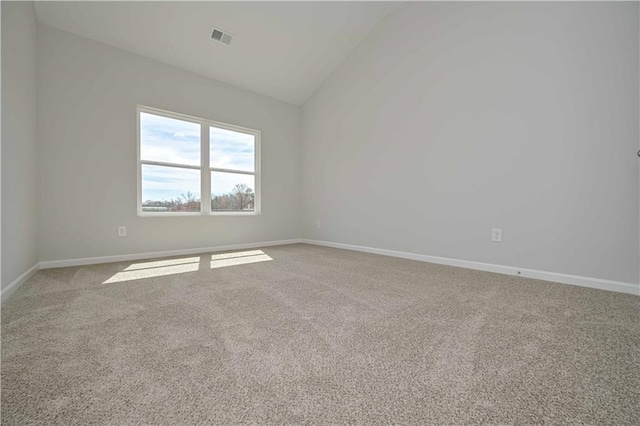 unfurnished room with carpet, visible vents, lofted ceiling, and baseboards