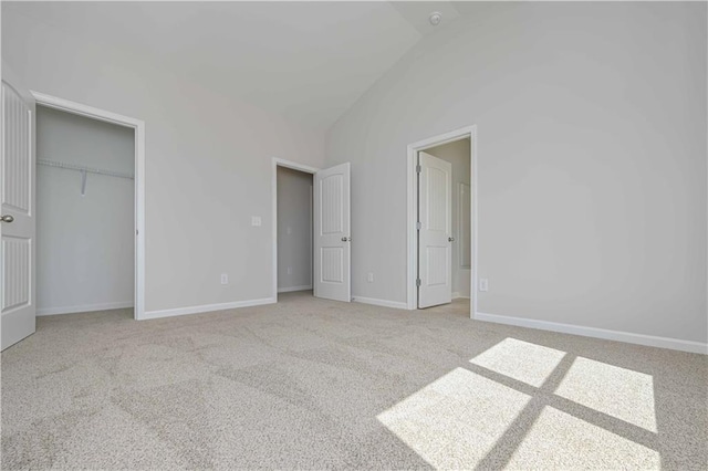 unfurnished bedroom with baseboards, a closet, carpet, and vaulted ceiling