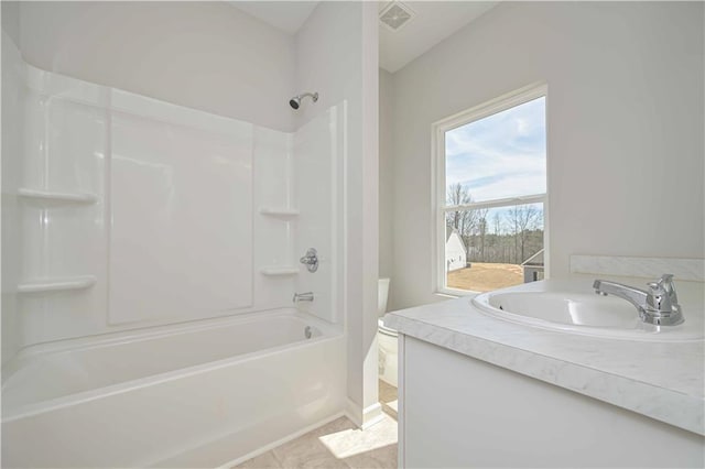 bathroom featuring toilet, visible vents, vanity, and bathing tub / shower combination