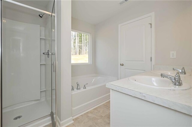 bathroom featuring visible vents, a shower stall, a bath, and a sink