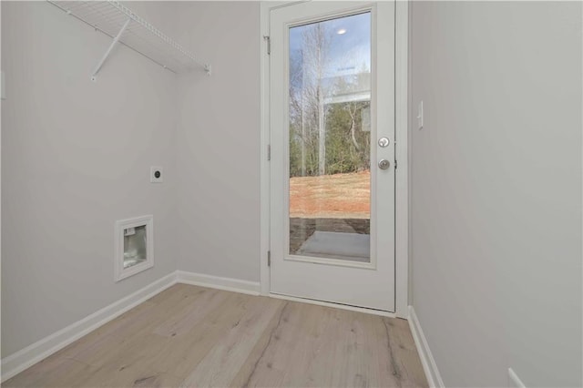 clothes washing area featuring hookup for an electric dryer, light wood-style flooring, laundry area, and baseboards