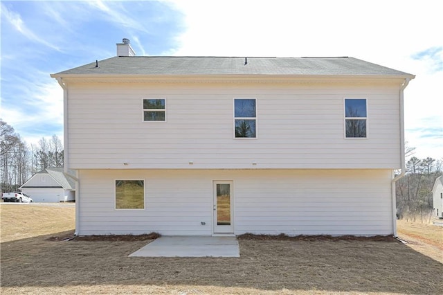 rear view of house featuring a chimney and a patio area