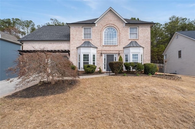 colonial house with brick siding and a front lawn