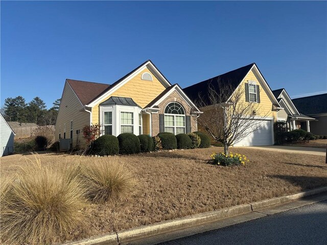 view of front of property with an attached garage, brick siding, and concrete driveway