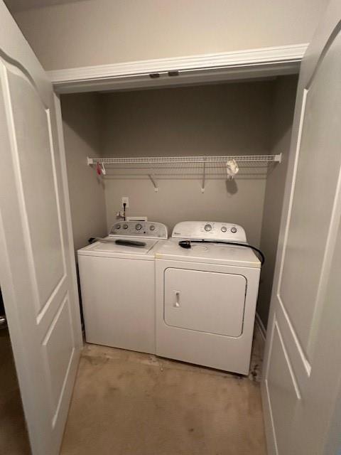 clothes washing area featuring separate washer and dryer and laundry area