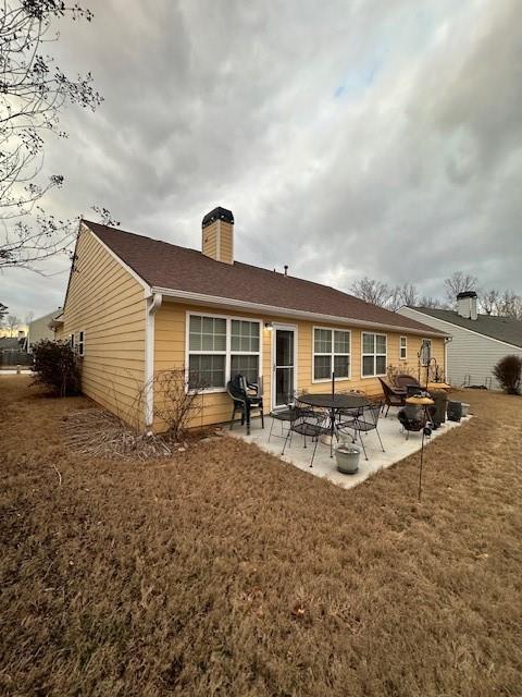 back of house with a yard and a patio