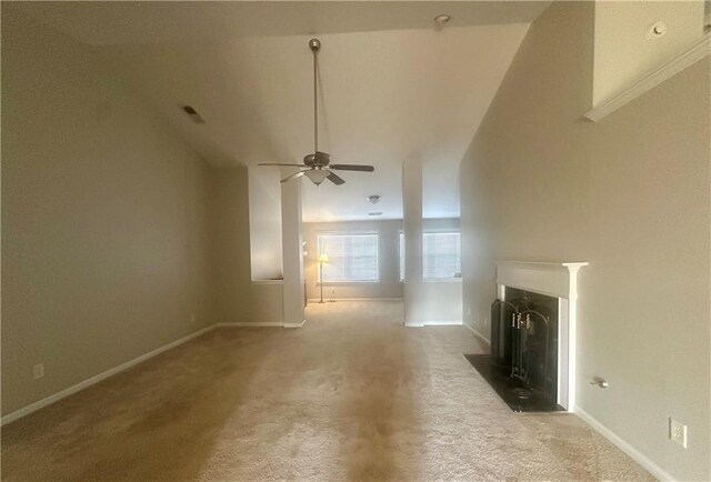 unfurnished living room featuring baseboards, a fireplace with flush hearth, a ceiling fan, and light carpet