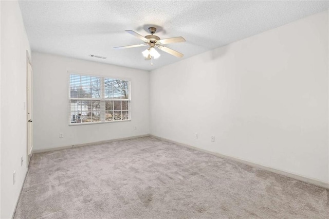 carpeted empty room featuring a textured ceiling and ceiling fan