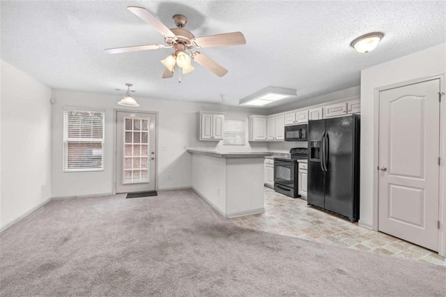 kitchen featuring black appliances, kitchen peninsula, ceiling fan, light colored carpet, and white cabinetry