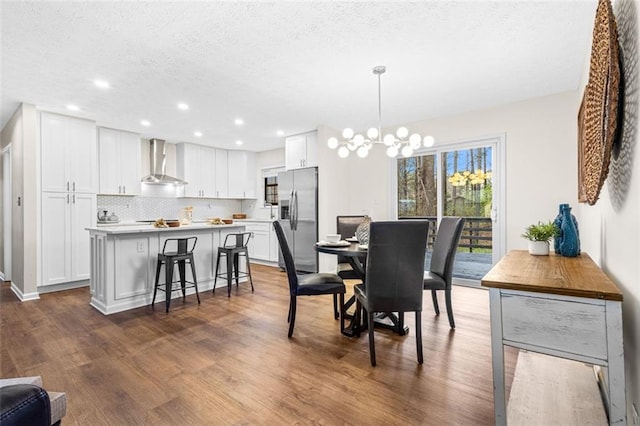 dining space featuring an inviting chandelier, recessed lighting, dark wood-style floors, and a textured ceiling