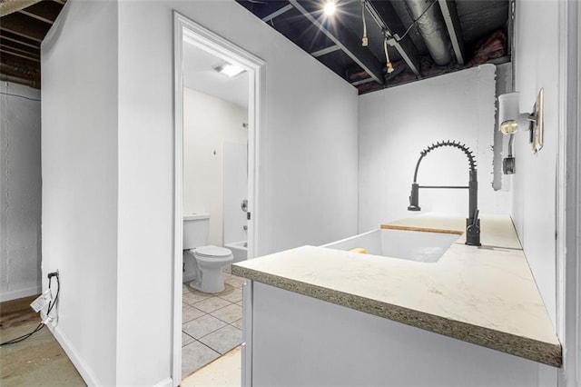 bathroom featuring vanity, toilet, baseboards, and walk in shower