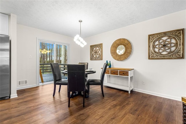 dining area with visible vents, baseboards, an inviting chandelier, a textured ceiling, and dark wood-style flooring