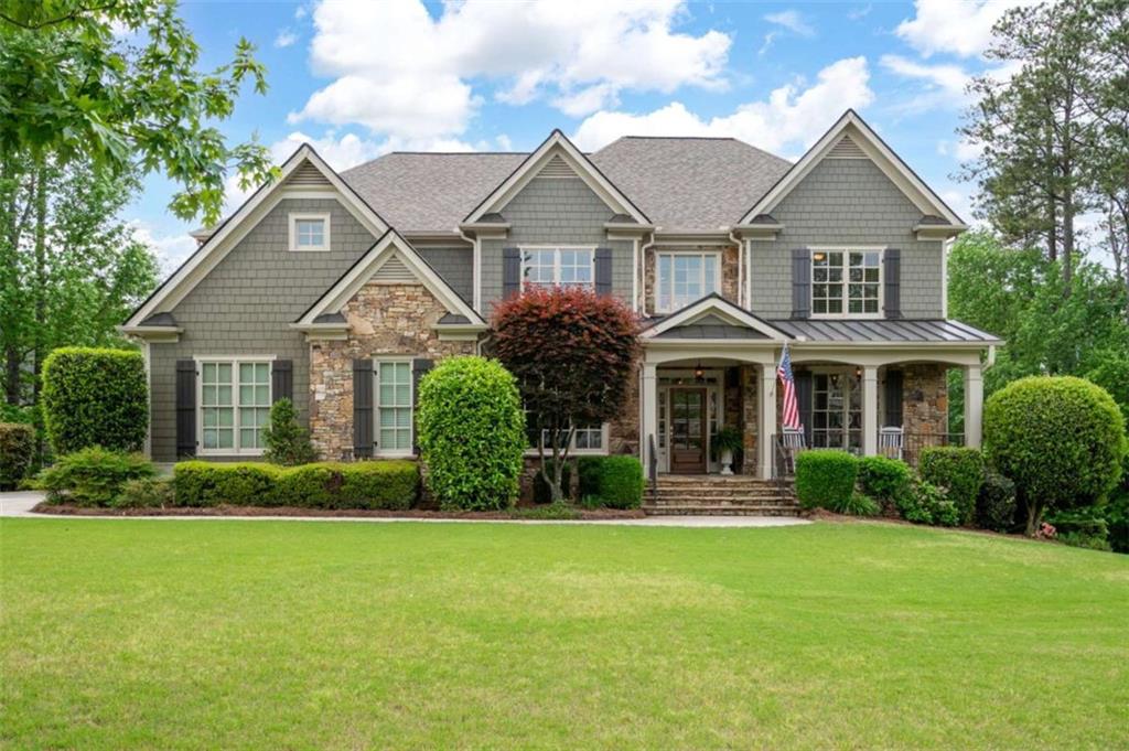 3309 NW Past Pl NW, Kennesaw, GA 30152 - craftsman-style house featuring covered porch, a standing seam roof, a front lawn, and stone siding