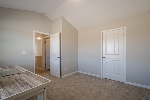 unfurnished bedroom with baseboards, lofted ceiling, and carpet floors