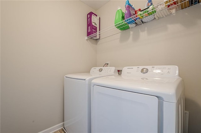 laundry area with laundry area, baseboards, and washer and clothes dryer