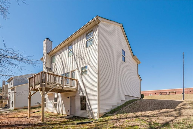 view of side of home featuring a chimney and a wooden deck