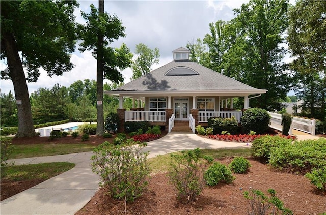 farmhouse featuring a porch and french doors