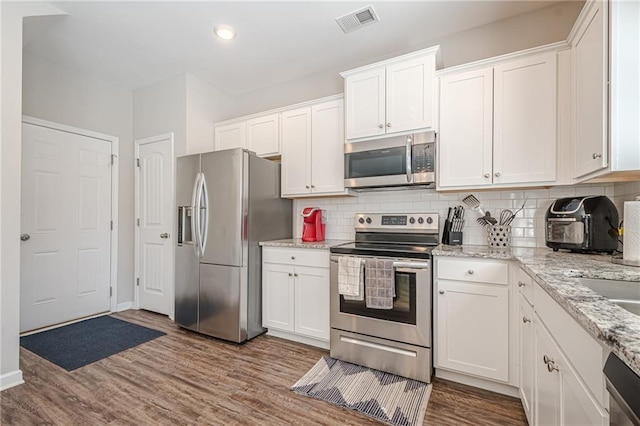 kitchen with dark wood finished floors, visible vents, white cabinets, and stainless steel appliances