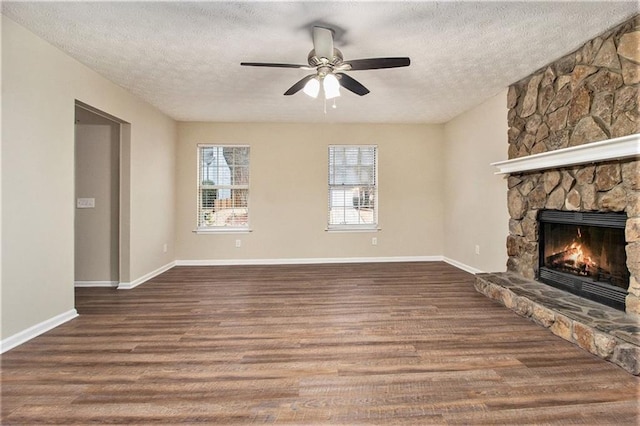 unfurnished living room with ceiling fan, a fireplace, a textured ceiling, and hardwood / wood-style flooring