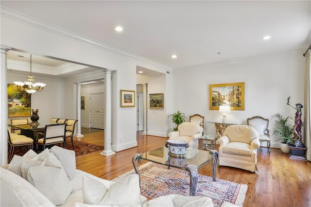 living room with a chandelier, recessed lighting, light wood-style floors, ornate columns, and crown molding