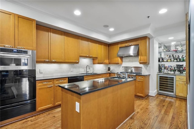 kitchen with a warming drawer, double wall oven, a sink, beverage cooler, and under cabinet range hood