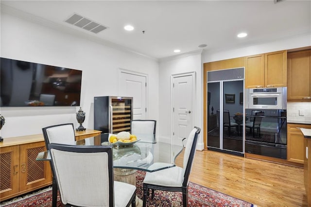 dining room with wine cooler, recessed lighting, visible vents, light wood-type flooring, and crown molding