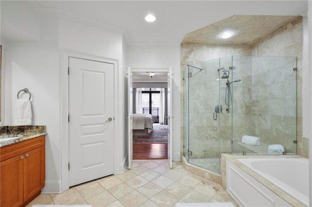 ensuite bathroom featuring tile patterned floors, ornamental molding, a shower stall, vanity, and a bath