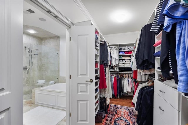 walk in closet with wood finished floors