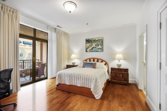 bedroom with baseboards, visible vents, ornamental molding, wood finished floors, and access to outside