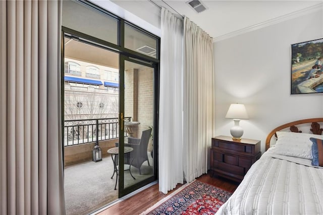 bedroom featuring access to outside, visible vents, crown molding, and wood finished floors