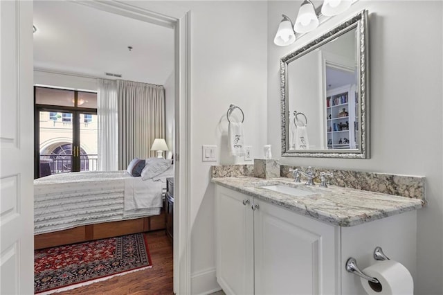 bathroom with ensuite bathroom, wood finished floors, and vanity