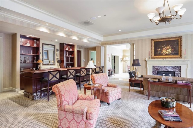 interior space with a notable chandelier, decorative columns, a fireplace, and crown molding