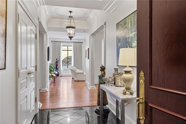 tiled entryway featuring ornate columns and ornamental molding