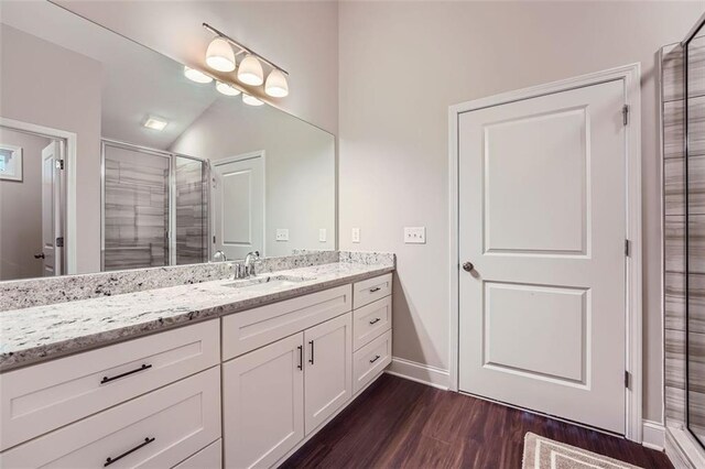 bathroom with vaulted ceiling, hardwood / wood-style floors, vanity, and an enclosed shower