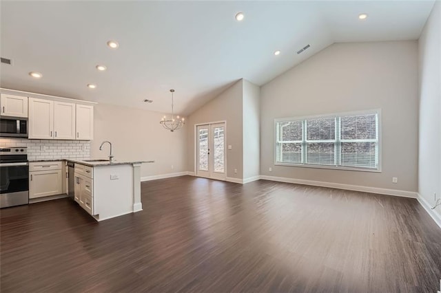 kitchen with appliances with stainless steel finishes, sink, white cabinets, dark hardwood / wood-style floors, and hanging light fixtures